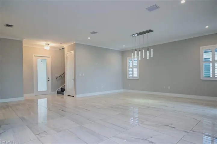 Empty room with ornamental molding, recessed lighting, and light marble finish floors