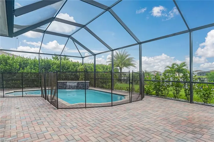 Swimming pool featuring a screen eclosure, and a patio