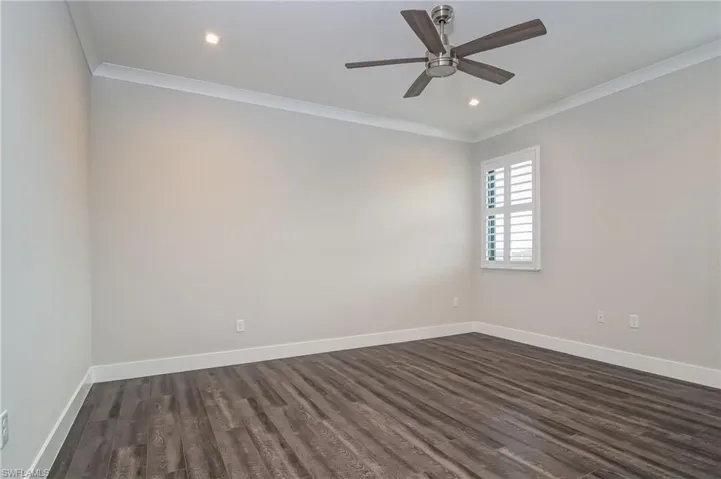 Unfurnished room featuring ornamental molding, dark wood-type flooring, ceiling fan, and recessed lighting