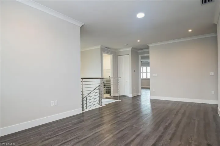 Unfurnished room featuring crown molding, dark wood-style flooring, and recessed lighting