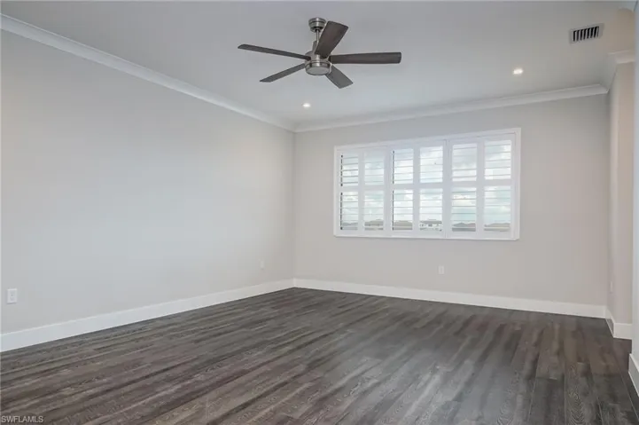 Unfurnished room featuring ceiling fan, crown molding, dark wood-style floors, and recessed lighting