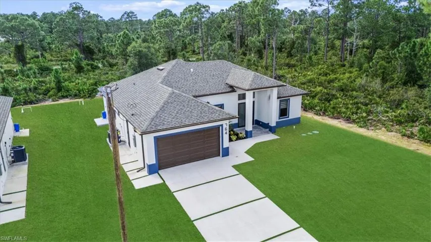 Aerial view of property and surrounding area with a forest