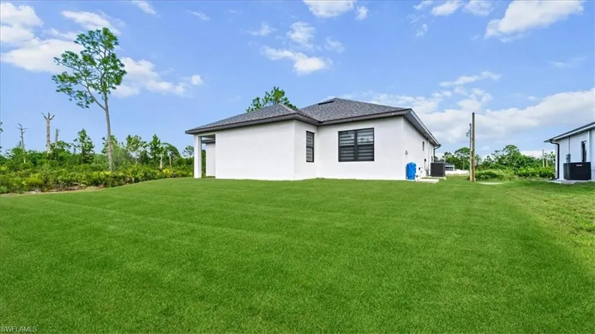 Rear view of house with a yard and stucco siding