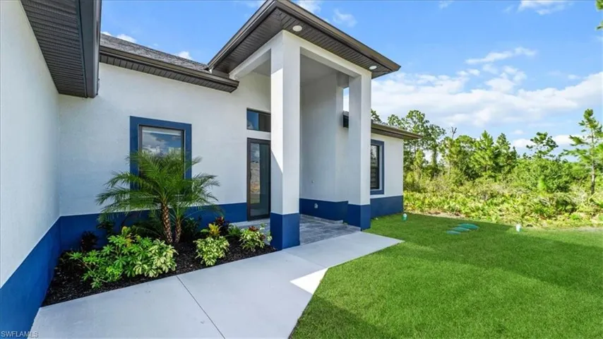 Entrance to property with a lawn and stucco siding