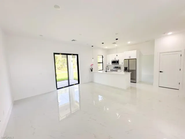 Unfurnished living room with sink and light tile floors