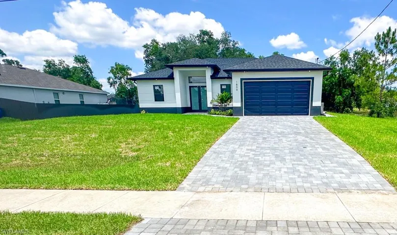 View of front of home featuring a garage and a front lawn