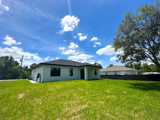 Rear view of property with a lawn