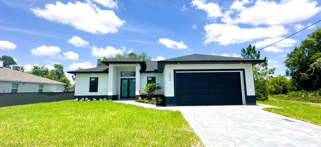 View of front of property featuring a front lawn and a garage