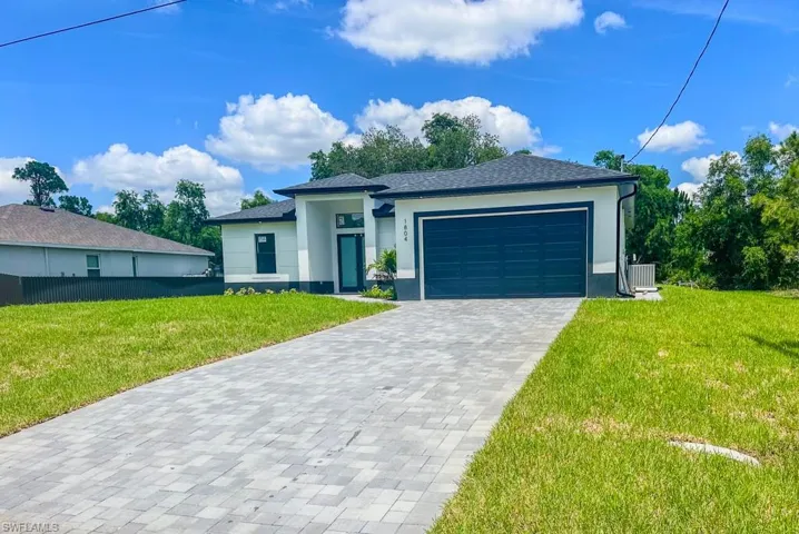 View of front of house with a garage, central AC, and a front yard