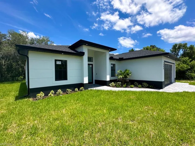 View of front facade featuring a garage and a front yard