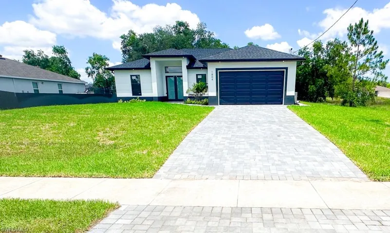 View of front of property featuring a garage and a front yard
