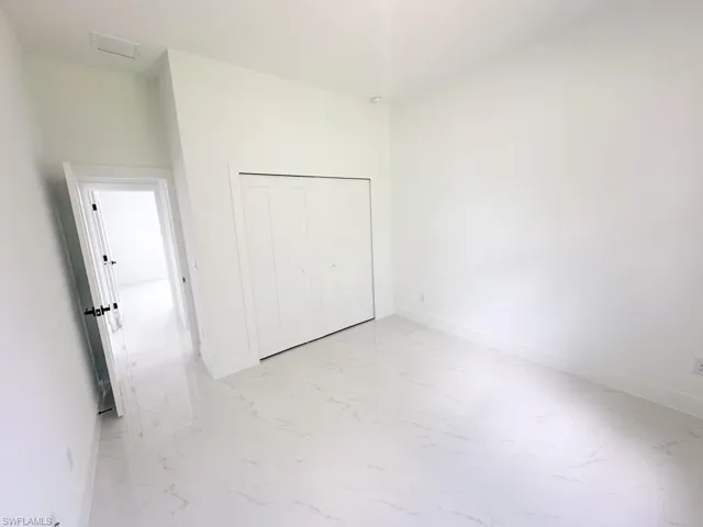 Unfurnished bedroom featuring a closet and light tile floors