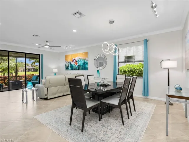 Kitchen, Dining Room, & Living Room with Track Lighting, & Sliders with Verticell Shade Leading to the Screened In Lanai with Lake View & Paver Lanai
