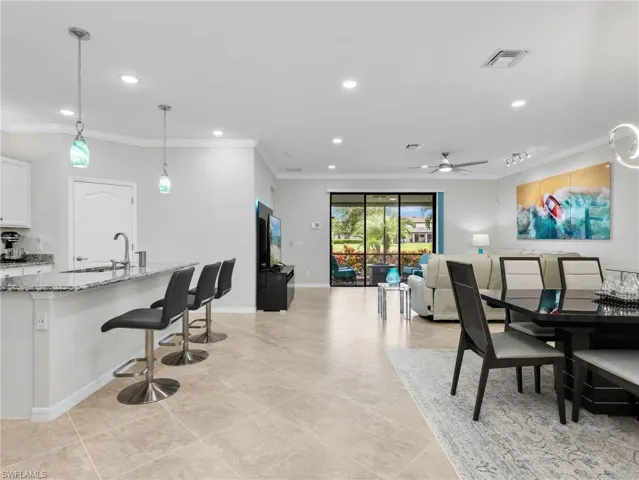 Kitchen Island, Living Room & Dining Room with Sliders with Verticell Shade Leading to Screened In Lanai