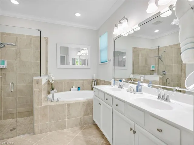 Primary Bedroom with Crown Molding, Pergo Laminate Flooring, Brand New Ceiling Fan, & 2 Large Walk-In Closets with Closet Organizers