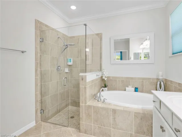 Primary En Suite Bathroom with Crown Molding, Tile Shower with Glass Enclosure & New Shower Head & Separate Handheld, Tiled Soaking Tub, & Large White Shaker Vanity with New Hardware, & Dual Sinks