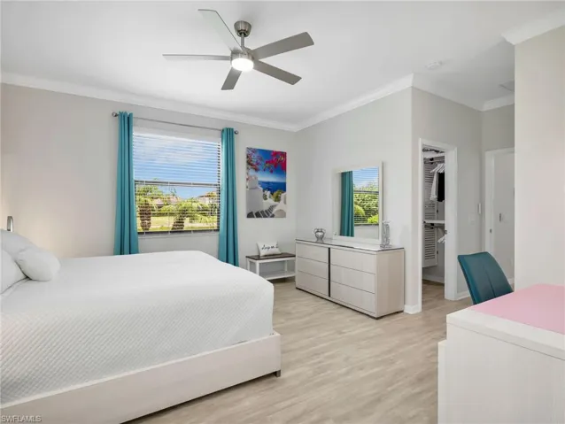 Primary Bedroom with Crown Molding, Pergo Laminate Flooring, Two Windows with Window Coverings, & Brand New Ceiling Fan