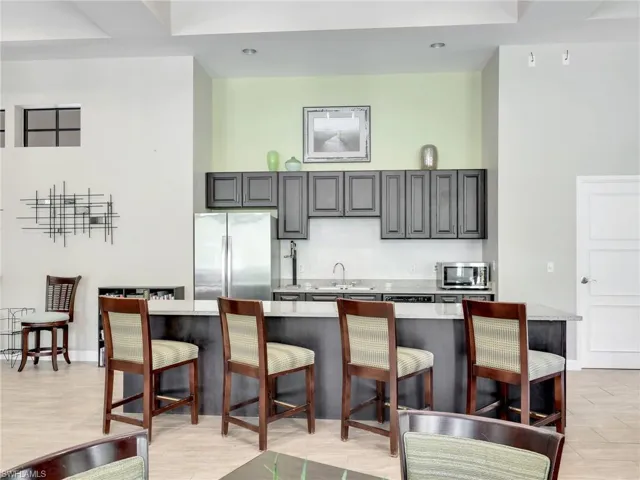 Clubhouse Community Room with Kitchenette,  Island, & Fireplace with Seating Area & TV