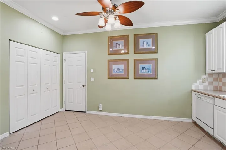 Unfurnished dining area with a ceiling fan, crown molding, and light tile patterned floors - Virtually Edited Image