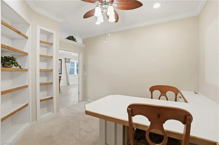 Dining room featuring light colored carpet, crown molding, built in features, a ceiling fan, and recessed lighting - Virtually Edited Image