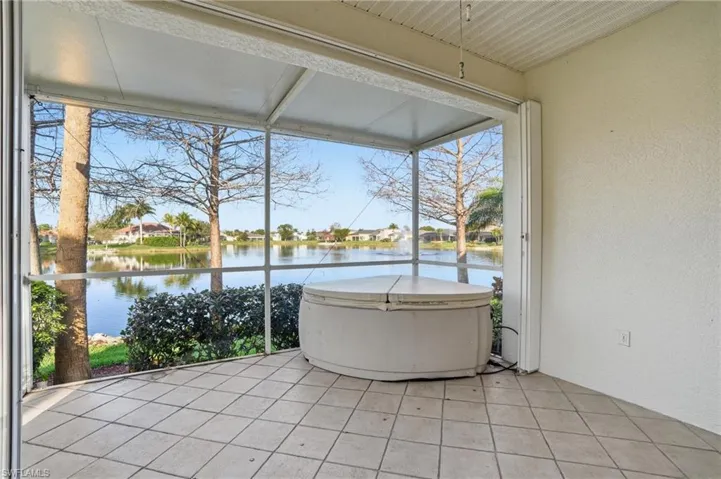 Sunroom / solarium with a water view and a residential view - Virtually Edited Image