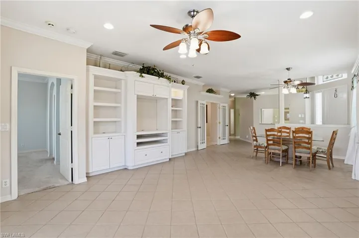 Dining space featuring ceiling fan, recessed lighting, ornamental molding, and light tile patterned flooring - Virtually Edited Image
