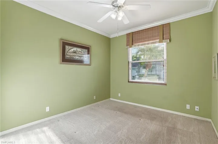 Spare room with crown molding, light carpet, and ceiling fan - Virtually Edited Image