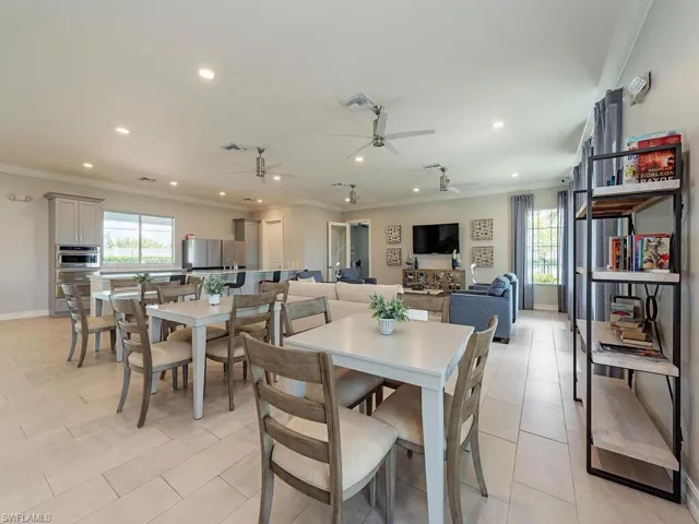 Tiled dining room featuring ceiling fan and crown molding