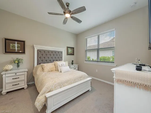 Carpeted bedroom featuring ceiling fan