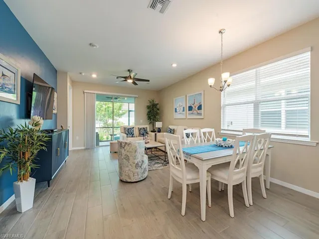 Dining room featuring light hardwood / wood-style floors and ceiling fan with notable chandelier