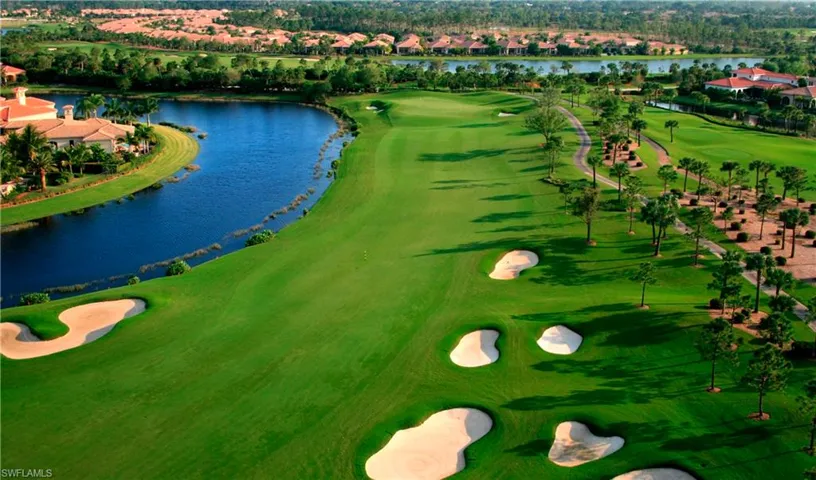 Aerial view of residential area featuring a large body of water and a golf course