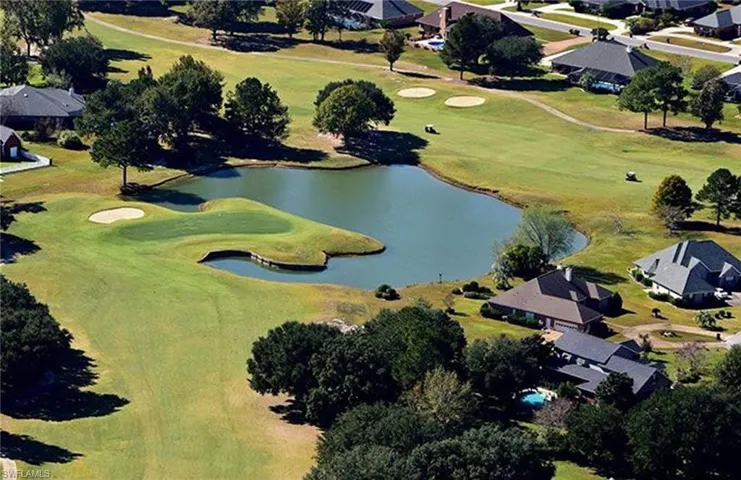 Aerial overview of property's location featuring nearby suburban area, a local golf course, and a large body of water