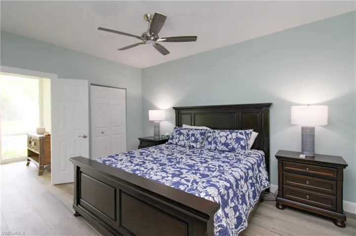 Bedroom with light hardwood / wood-style floors, a closet, ceiling fan, and multiple windows