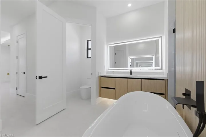 Bathroom featuring a marble finish shower and vanity