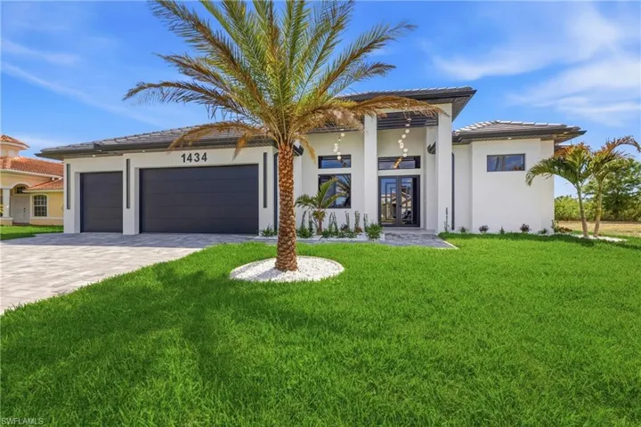 View of front of house featuring decorative driveway, french doors, a garage, a front yard, and a tile roof