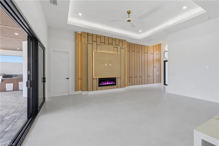 Spare room with a ceiling fan, a raised ceiling, and recessed lighting