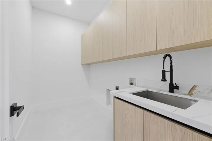 Unfurnished living room with ceiling fan, a large fireplace, finished concrete floors, recessed lighting, and a tray ceiling