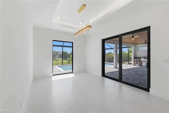 Empty room featuring wine cooler, recessed lighting, and a raised ceiling