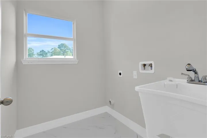 Laundry room featuring light marble finish flooring, electric dryer hookup, and washer hookup