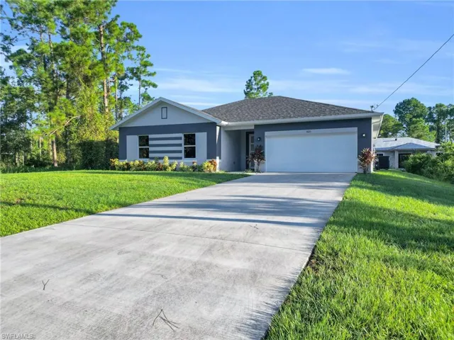 Ranch-style house with a front yard, an attached garage, concrete driveway, and stucco siding