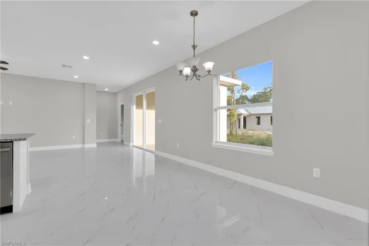 Unfurnished dining area with light marble finish floors and hanging lights