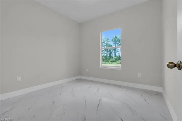 Spare room featuring light marble finish floors