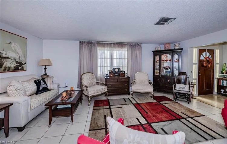 Living room with light tile patterned floors and a textured ceiling