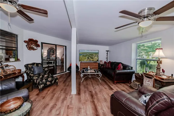 Living room with light wood-type flooring and ceiling fan