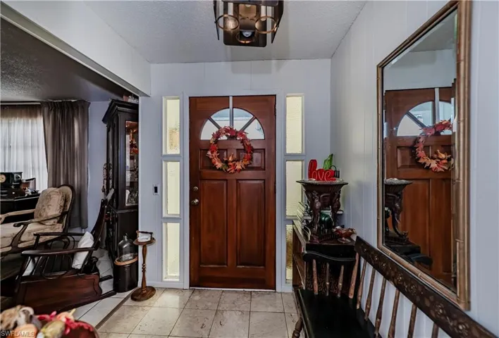 Tiled entrance foyer featuring an inviting chandelier and a textured ceiling