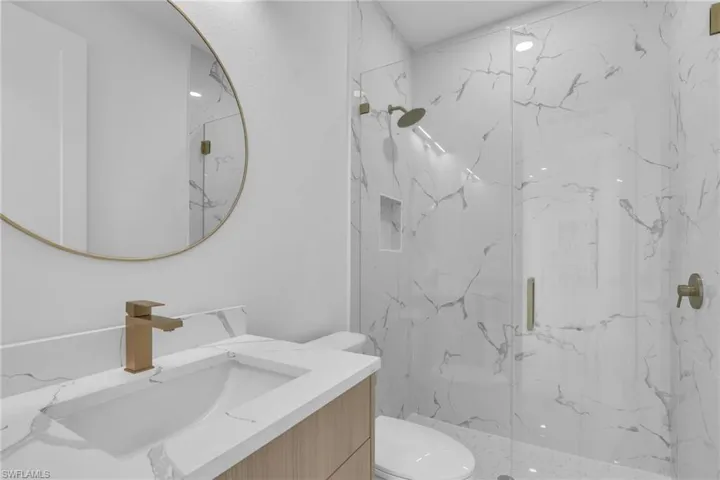 Full bathroom with vanity and a marble finish shower