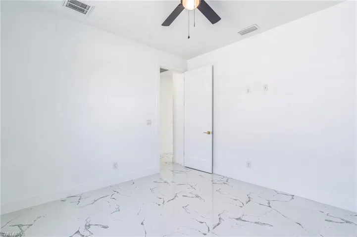Spare room with baseboards and a ceiling fan