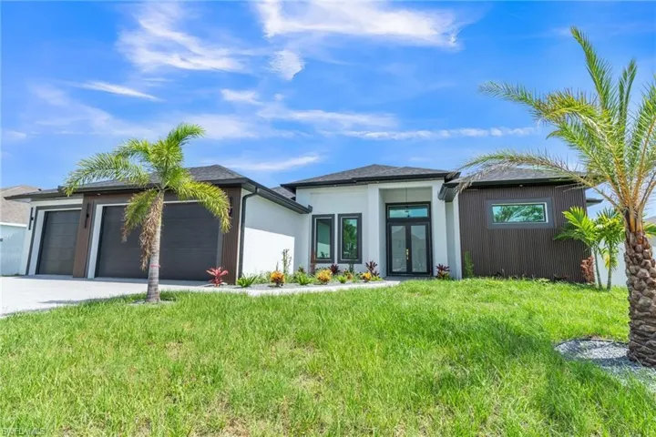 Prairie-style house featuring a garage, a front lawn, and concrete driveway