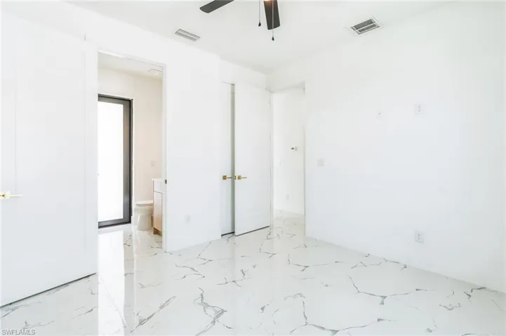 Unfurnished bedroom with ceiling fan and light marble finish flooring