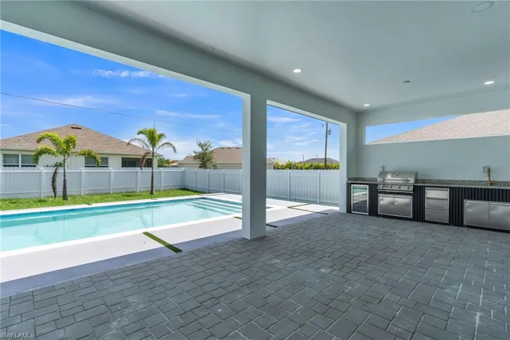 View of swimming pool with exterior kitchen, a patio area, and a fenced backyard